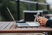 man holding phone and laptop