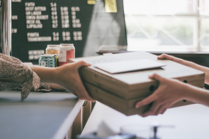 A box being handed from one person to another in relation to marketing strategies for small business