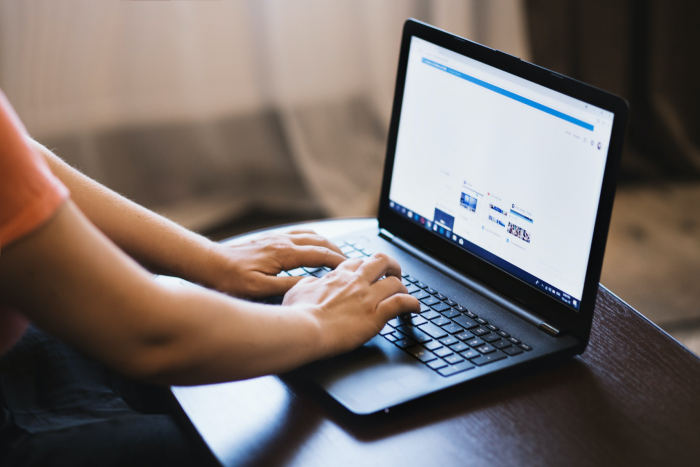 A person typing on a computer to demonstrate automated SEO software
