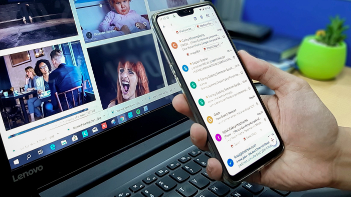 Person checking their email inbox with an iPhone